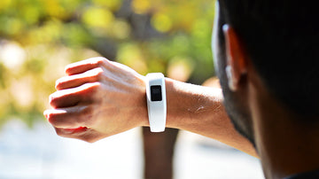 A person outdoors checking their watch, wondering 'How long should I ground each day?'